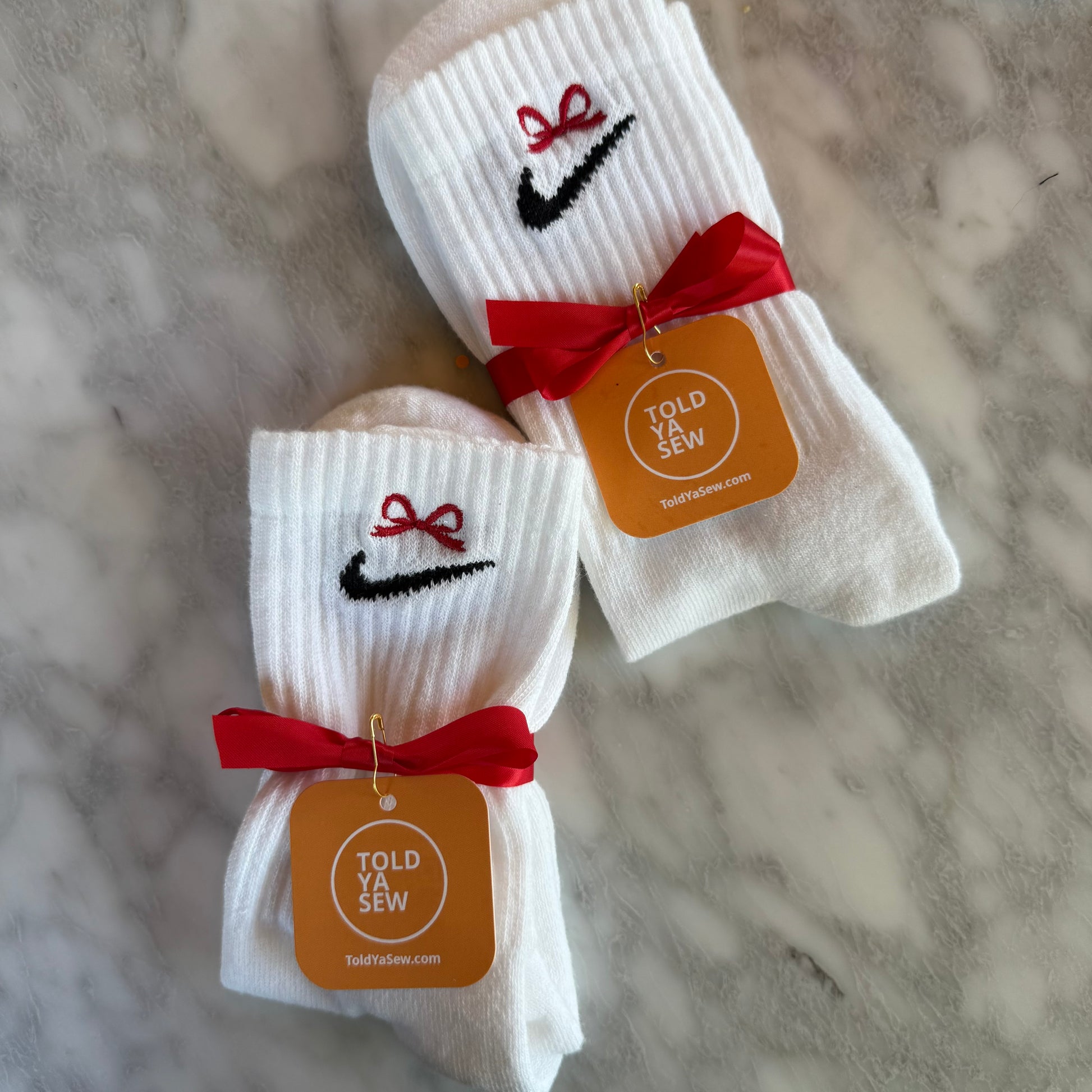 White socks with Nike logo and red bows.